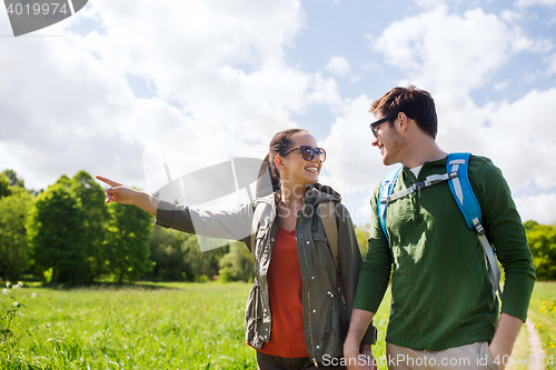 Image of happy couple with backpacks hiking outdoors