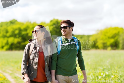 Image of happy couple with backpacks hiking outdoors