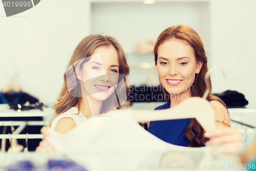 Image of happy women with shopping bags at clothing shop