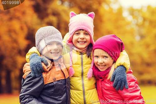Image of group of happy children hugging in autumn park