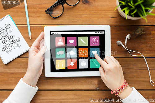 Image of close up of woman with tablet pc on wooden table