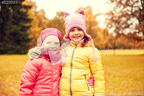 Image of two happy little girls hugging in autumn park