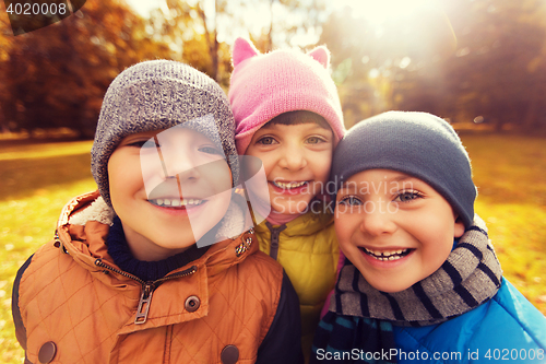 Image of group of happy children hugging in autumn park