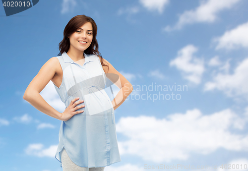 Image of happy pregnant woman touching her big belly