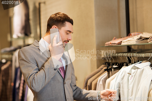 Image of happy man calling on smartphone at clothing store