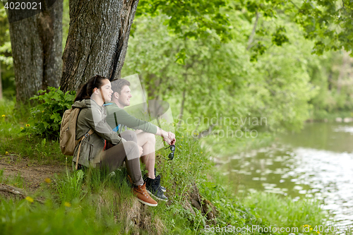 Image of smiling couple with backpacks in nature