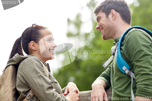 Image of smiling couple with backpacks in nature