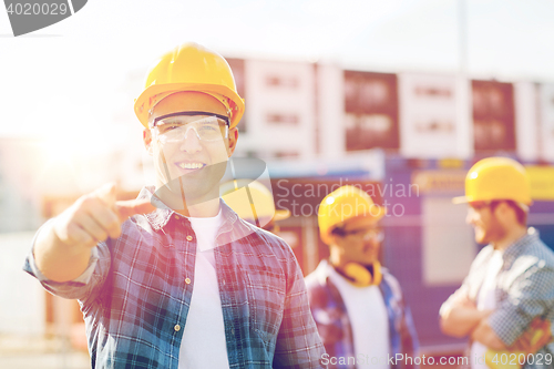 Image of group of smiling builders in hardhats outdoors