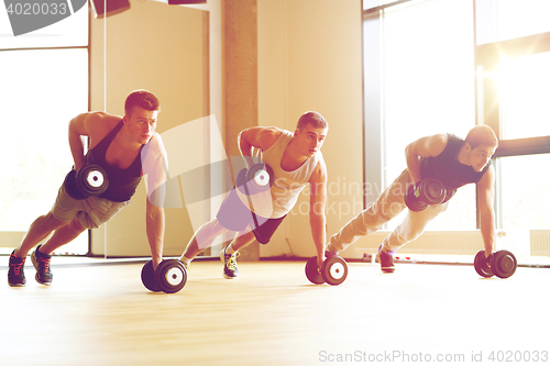 Image of group of men with dumbbells in gym