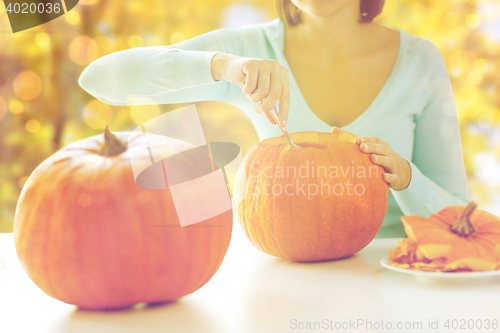 Image of close up of woman carving pumpkins for halloween