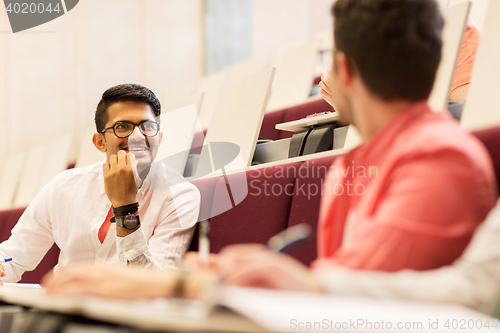 Image of group of students with notebooks in lecture hall