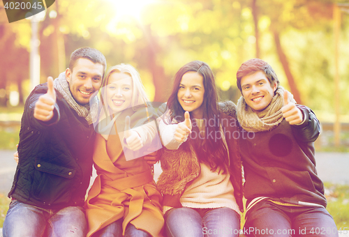 Image of group of friends having fun in autumn park