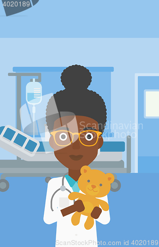 Image of Pediatrician doctor holding teddy bear.