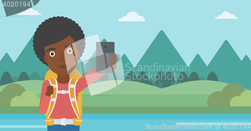 Image of Woman with backpack making selfie.