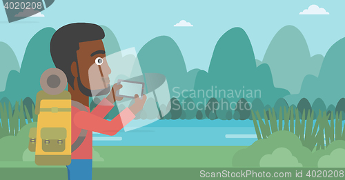 Image of Man with backpack taking photo.