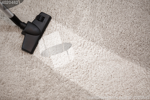 Image of Head of vacuum cleaner in dusty carpet and clean strip