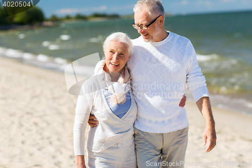 Image of happy senior couple hugging on summer beach