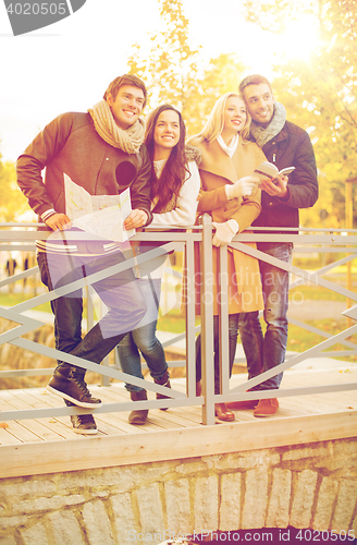 Image of couples with tourist map in autumn park