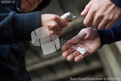 Image of close up of addict buying dose from drug dealer