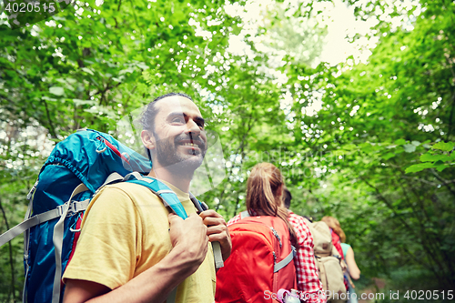 Image of group of smiling friends with backpacks hiking