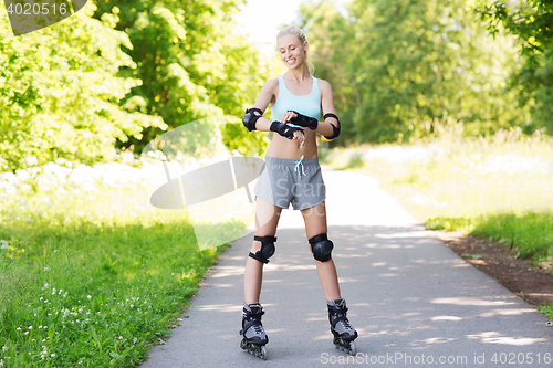 Image of happy young woman in rollerblades riding outdoors