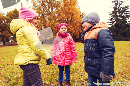 Image of group of happy children talking in autumn park