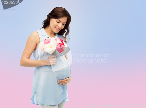 Image of happy pregnant woman with flowers touching belly