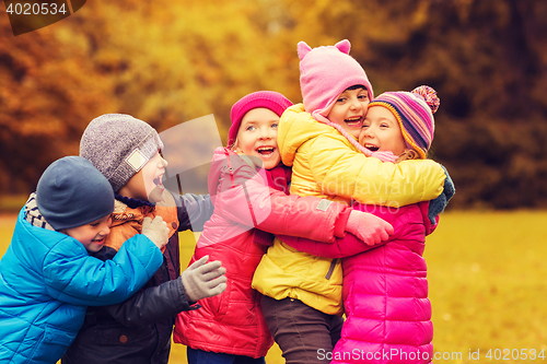 Image of group of happy children hugging in autumn park