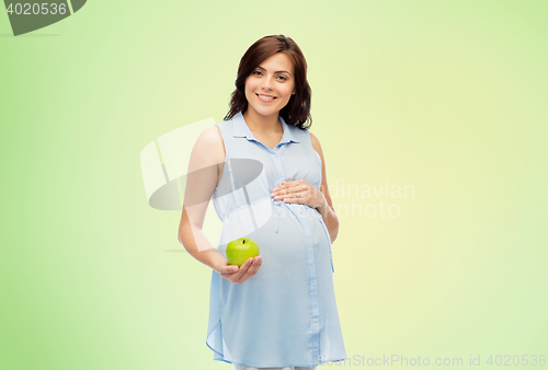 Image of happy pregnant woman holding green apple