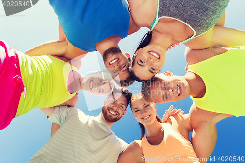 Image of group of happy sporty friends in circle outdoors