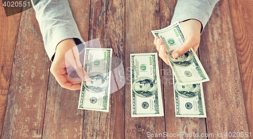 Image of close up of woman hands counting us dollar money