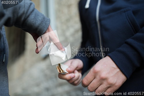 Image of close up of addict buying dose from drug dealer