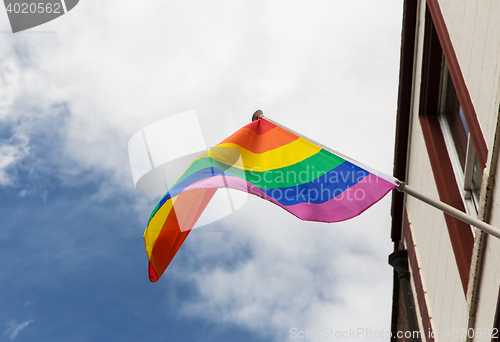 Image of close up of rainbow gay pride flag waving on building