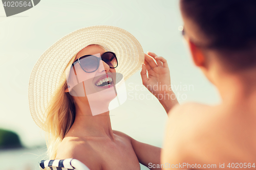 Image of happy couple sunbathing on summer beach