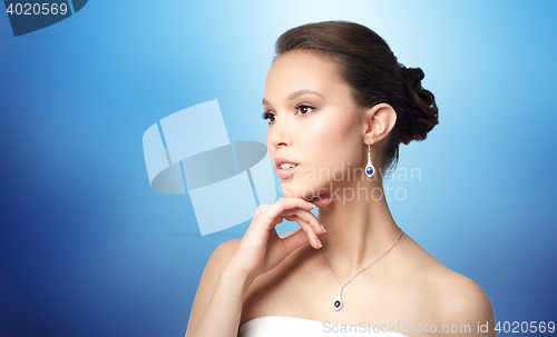 Image of beautiful asian woman with earring and pendant