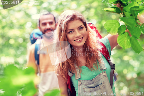 Image of group of smiling friends with backpacks hiking