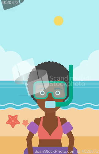 Image of Woman with snorkeling equipment on the beach.