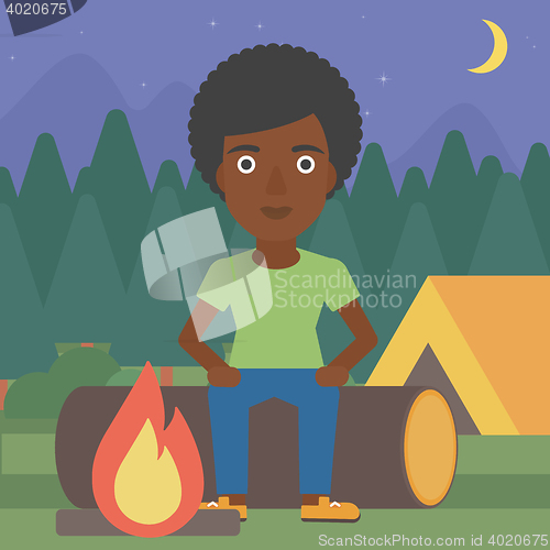 Image of Woman sitting on log in the camping.