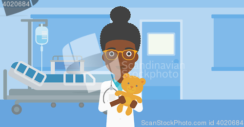 Image of Pediatrician doctor holding teddy bear.