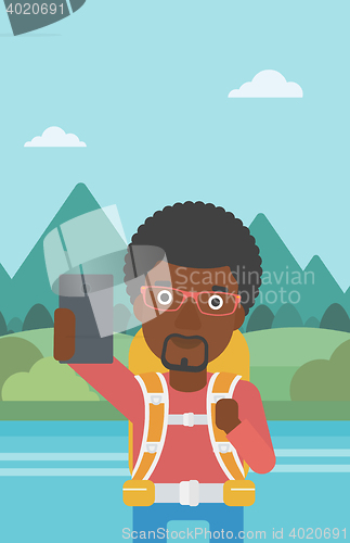 Image of Man with backpack making selfie.