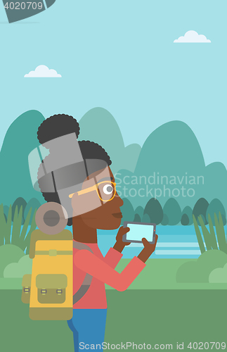 Image of Woman with backpack taking photo.