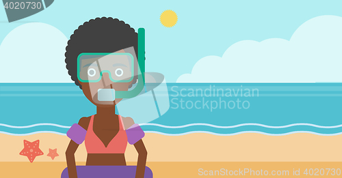 Image of Woman with snorkeling equipment on the beach.