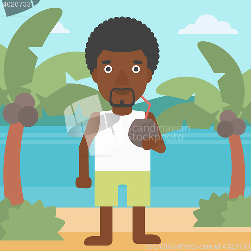 Image of Man drinking coconut cocktail on the beach.