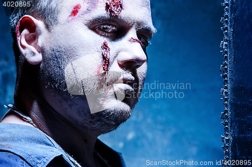 Image of Bloody Halloween theme: crazy killer as young man with blood