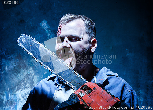 Image of Bloody Halloween theme: crazy killer as butcher with electric saw