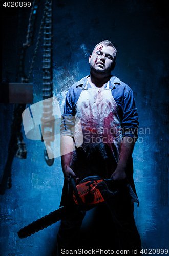 Image of Bloody Halloween theme: crazy killer as butcher with electric saw