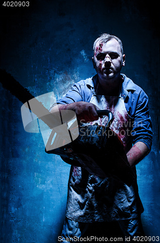 Image of Bloody Halloween theme: crazy killer as butcher with electric saw