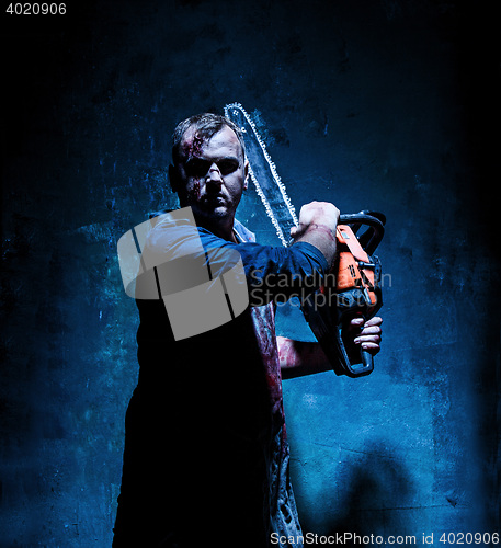 Image of Bloody Halloween theme: crazy killer as butcher with electric saw