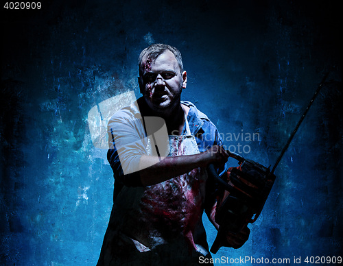 Image of Bloody Halloween theme: crazy killer as butcher with electric saw