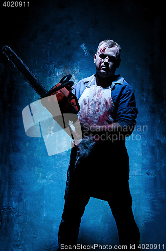 Image of Bloody Halloween theme: crazy killer as butcher with electric saw